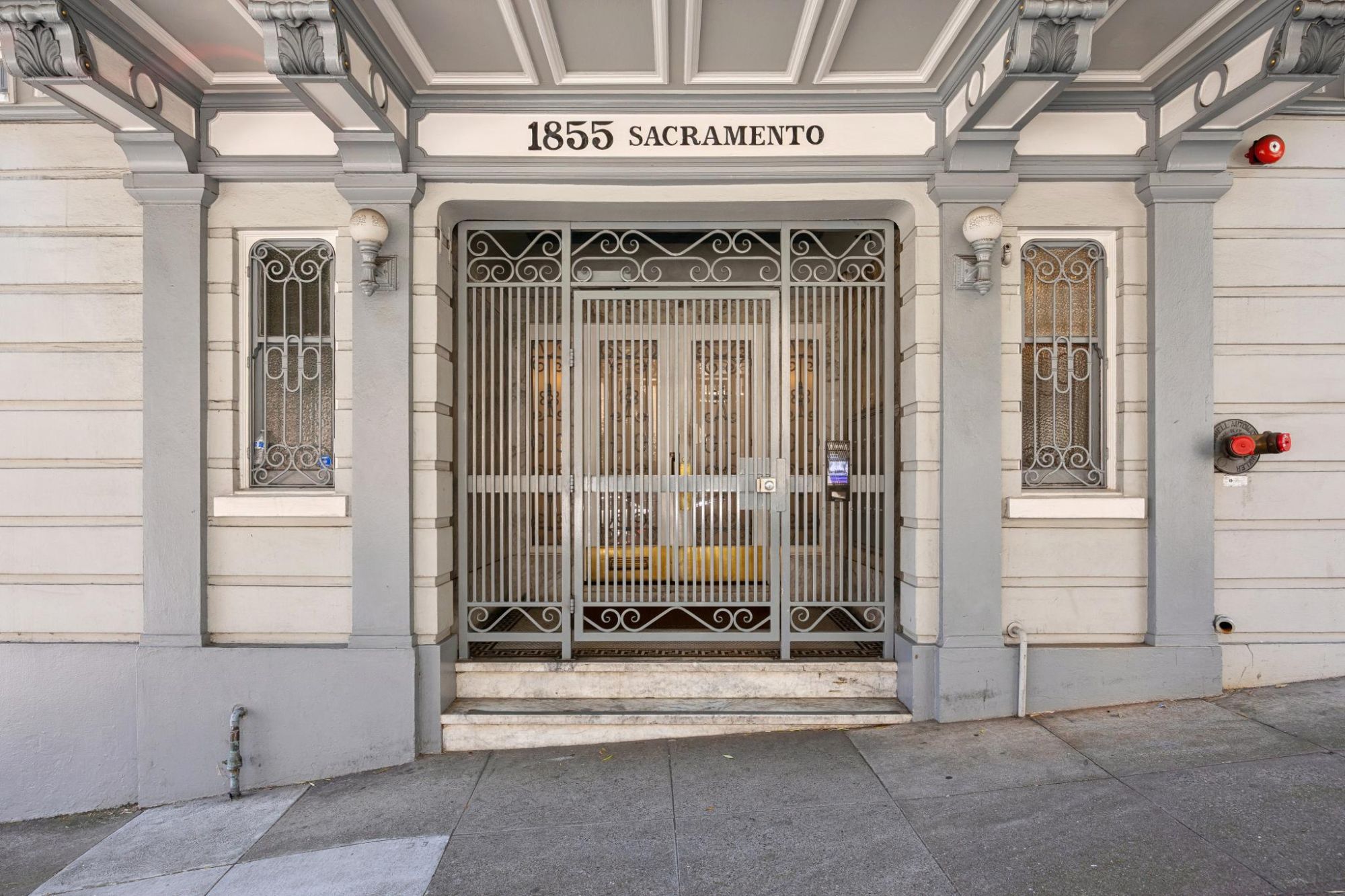 Building entrance at 1855 Sacramento with ornamental iron gates and marble steps