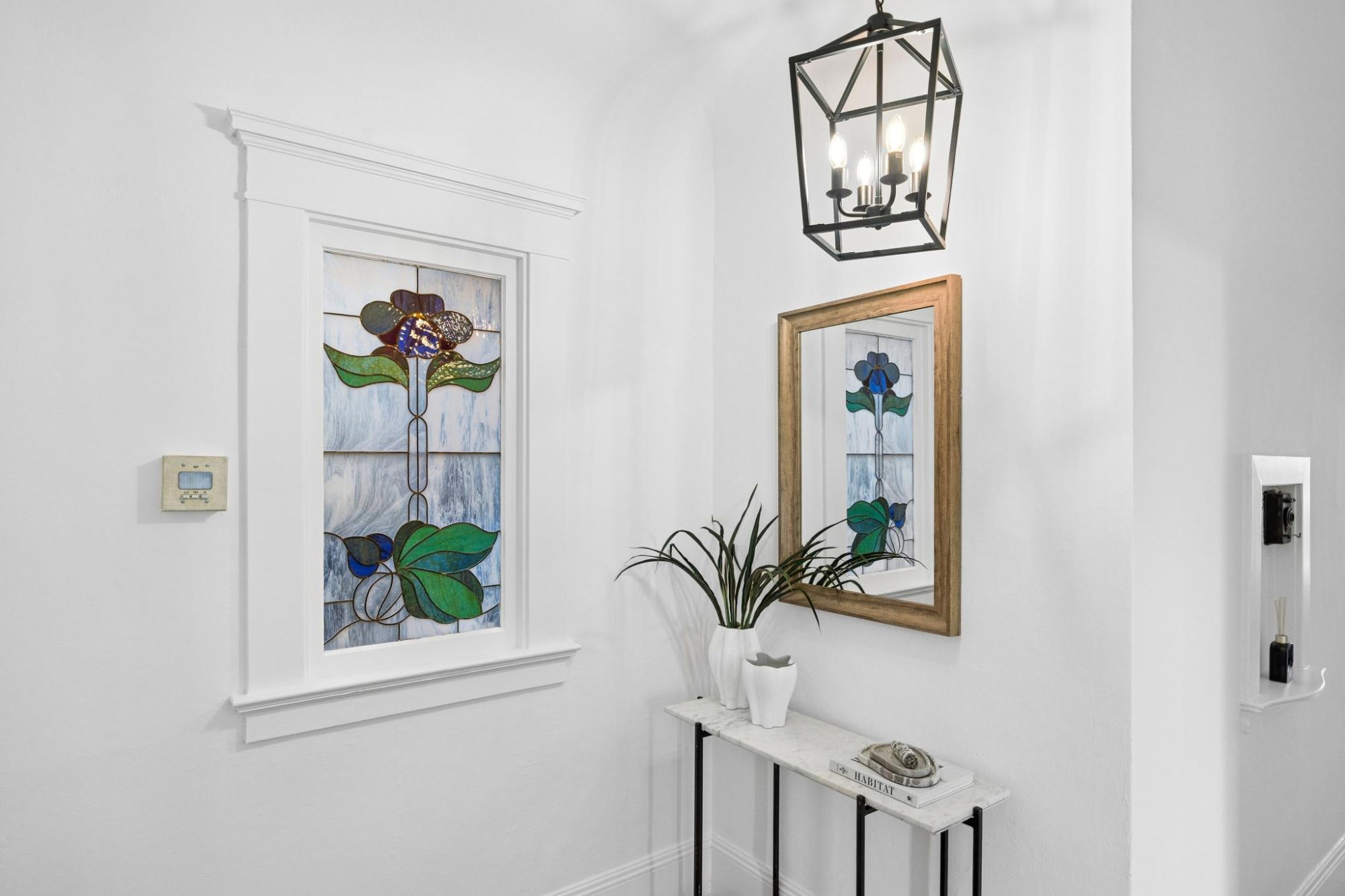 Original floral stained glass window in the entry hall, framed in white trim